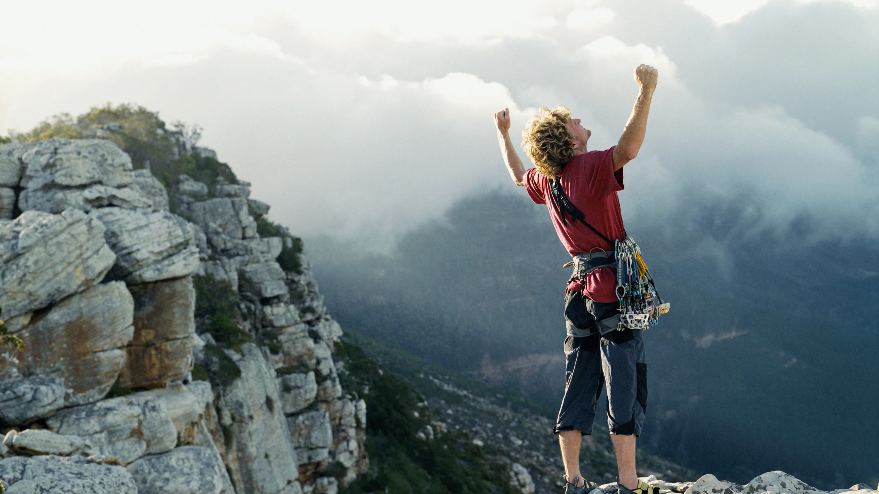 A person who has climbed the top of a hill, symbolising personal growth and achievement